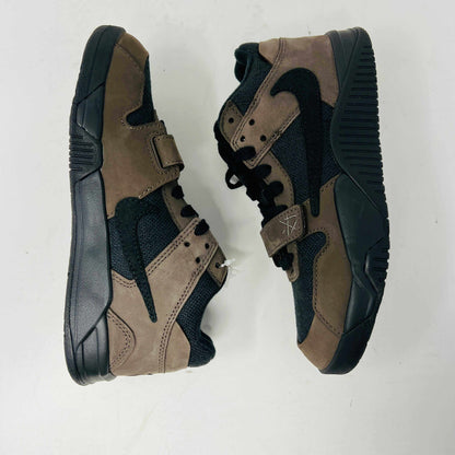 The Jordan Jumpman Jack TR Travis Scott Dark Mocha (PS) features brown and black high-top sneakers with suede material, black rubber soles, a forefoot strap, and a prominent black swoosh design. They are displayed side by side on a white background.