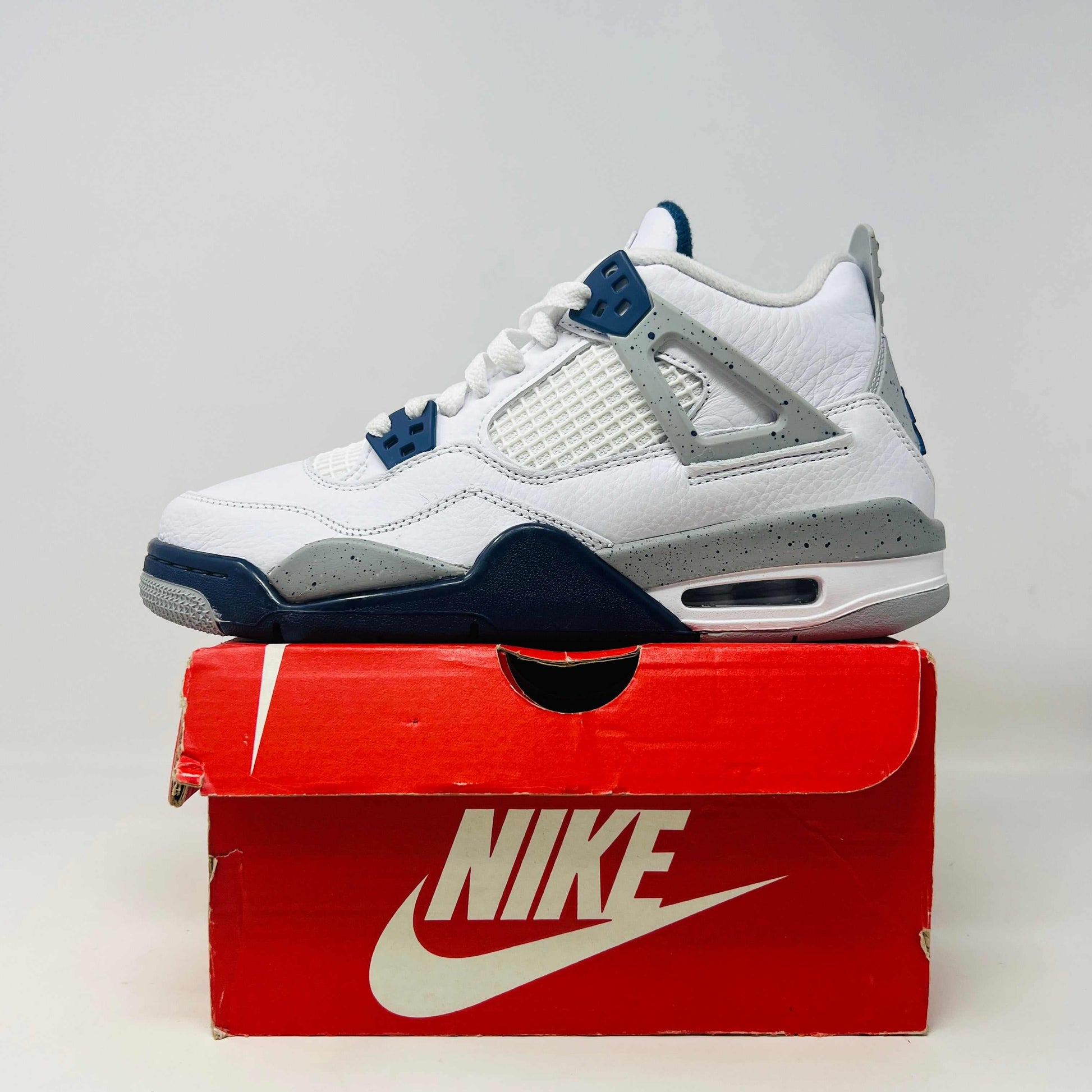 Jordan 4 Retro Midnight Navy GS sneakers on a replacement box, 2022 release.