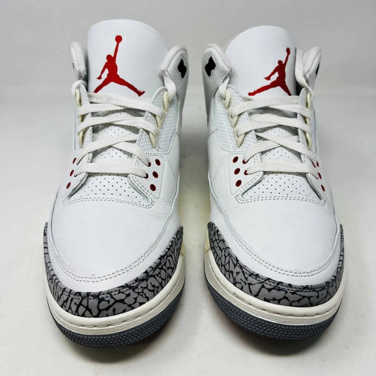 The Jordan 3 Retro White Cement Reimagined sneaker, size 13, features authentic quality with elephant print accents, black and red details, and a visible air unit. It comes in a matching Nike Air shoebox highlighting branding details.