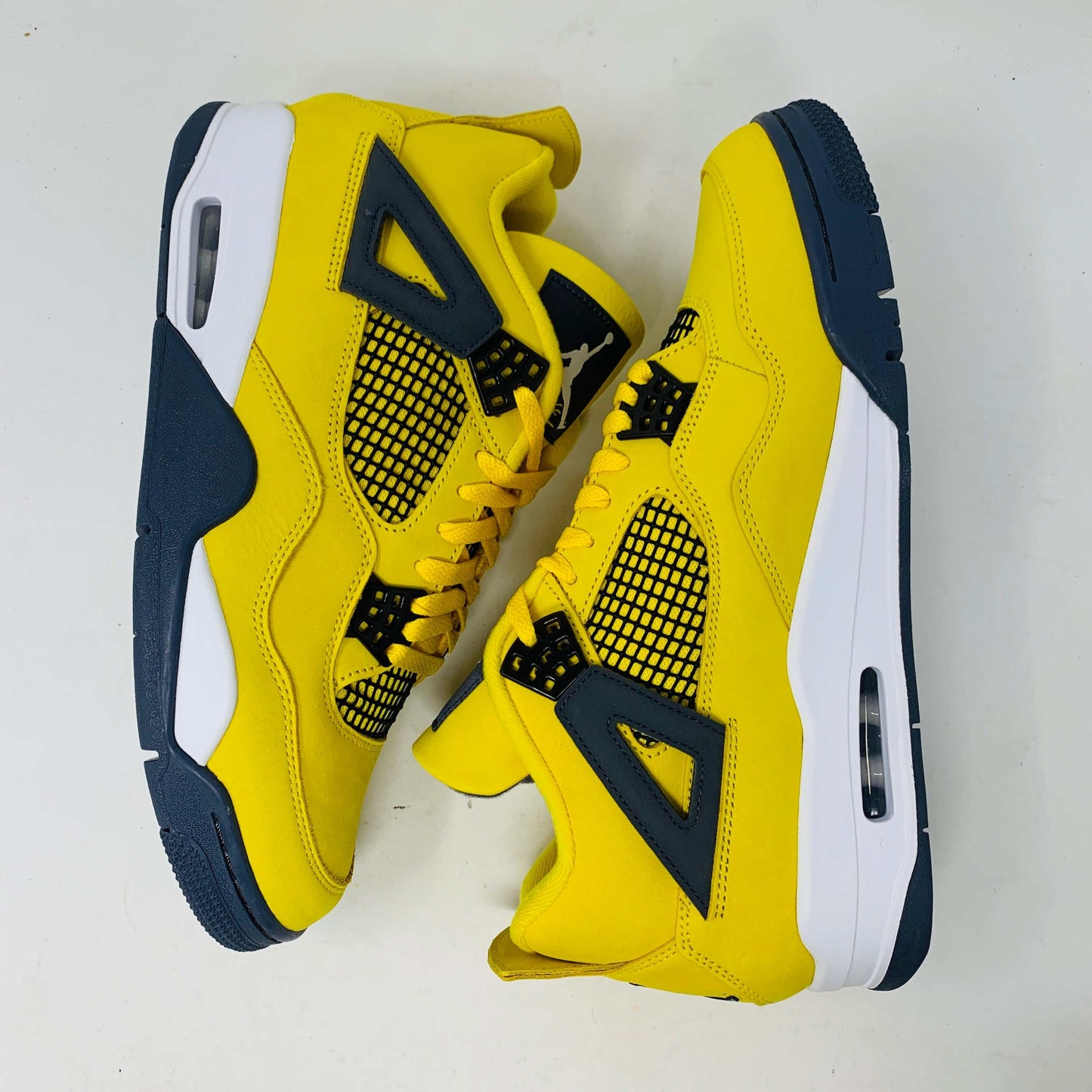 Jordan 4 Lightning sneakers in bold yellow and black colorway with lightning bolt accents.