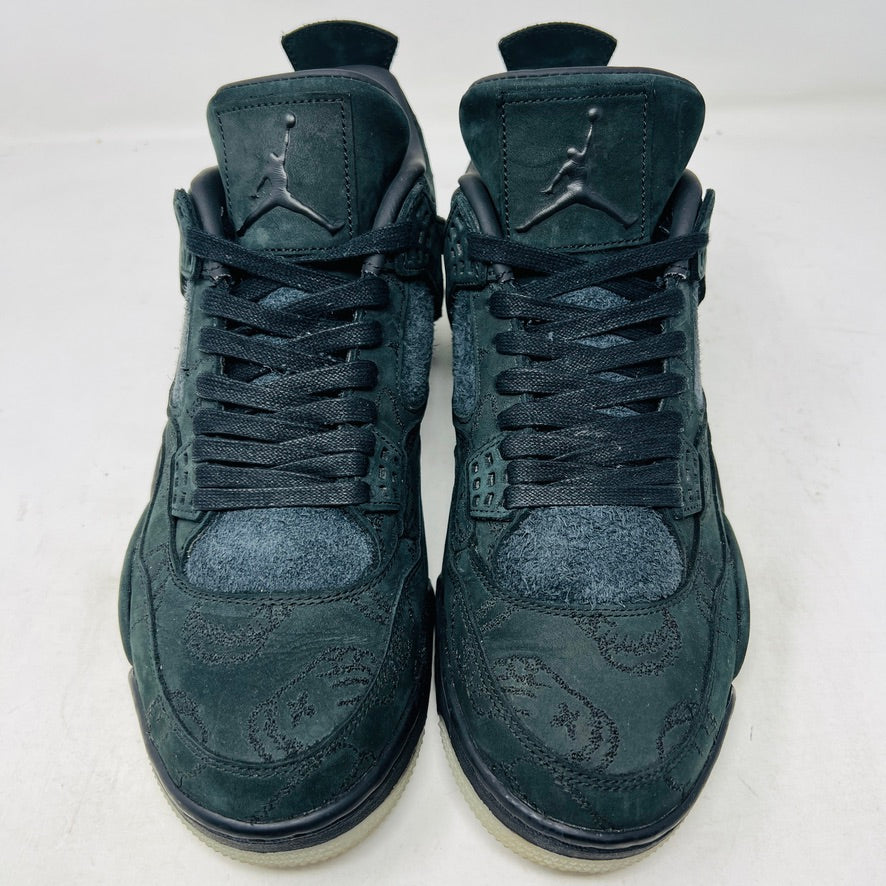 A dark green suede sneaker with a textured design, reminiscent of OG ALL styles, sits atop a matching box. Tagged size 10.5, it features a small red Jumpman logo and includes a XX AIR keychain from its 2017 release. Product: Jordan 4 Retro Kaws Black by Jordan.