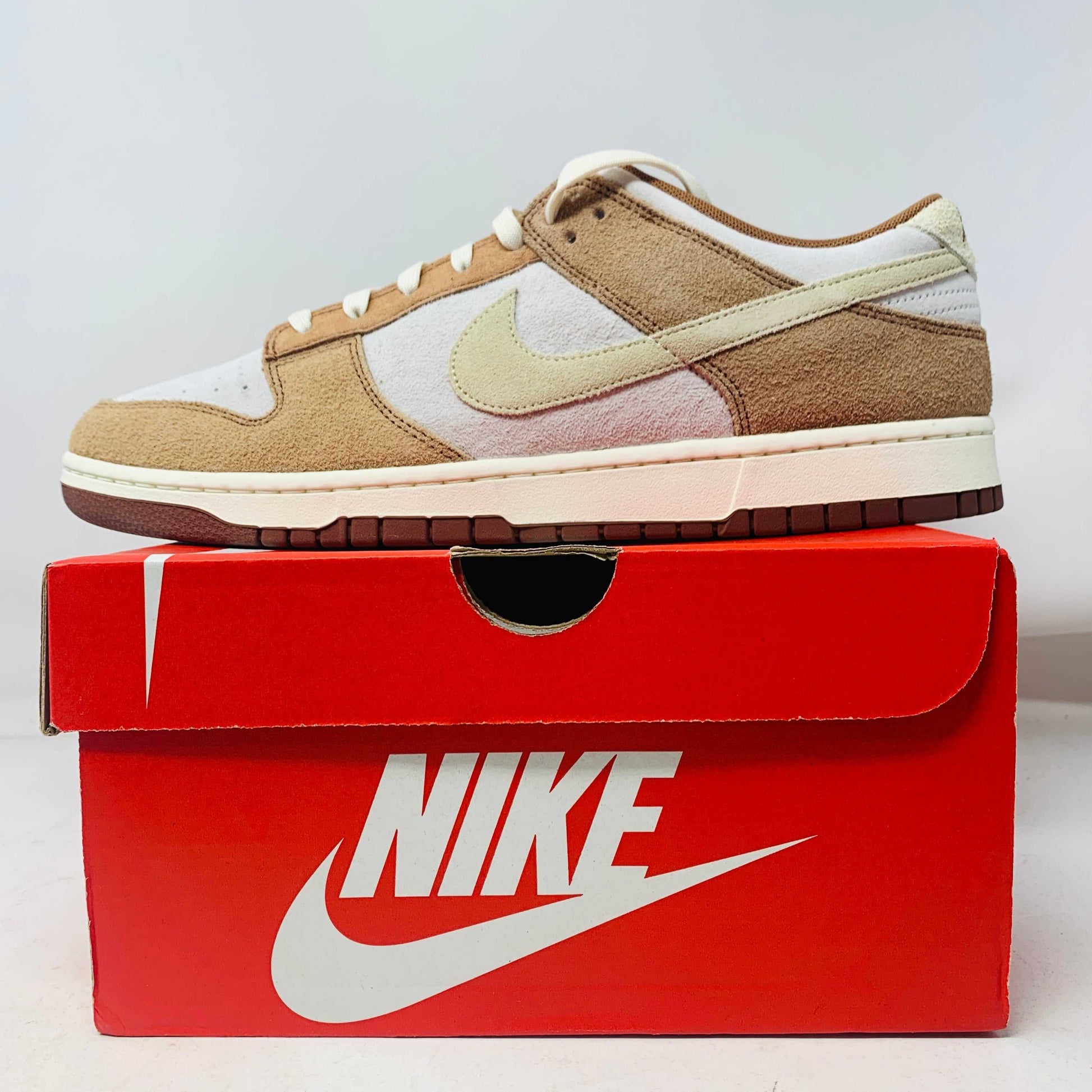 Nike Dunk Low Medium Curry sneakers, brand new, displayed on a red Nike box.