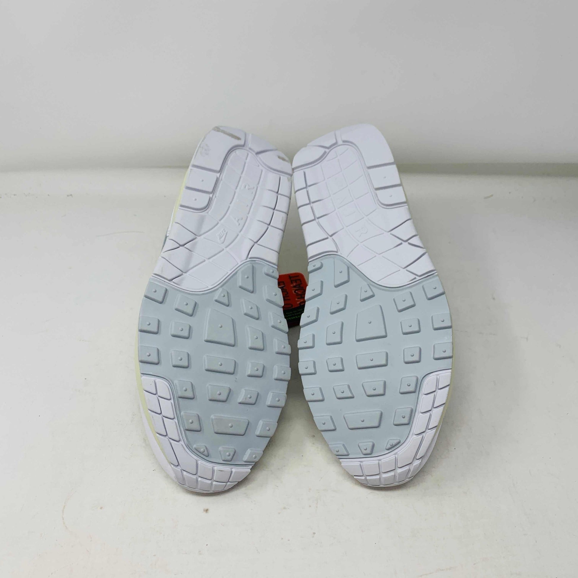 The Nike Air Max 1 Patta Waves White, a brand new sneaker, features a visible air cushion sole and swoosh logo. It comes elegantly displayed on a matching P.G.L.F.A. box with extra laces in a plastic bag attached to the tongue.