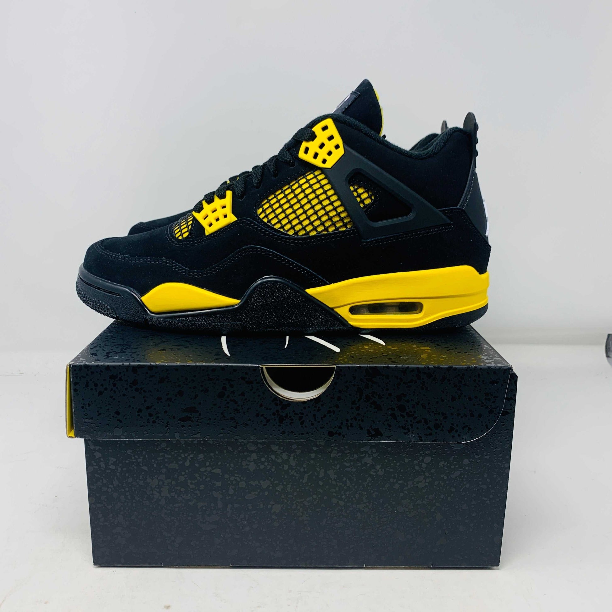 Jordan 4 Thunder 2023 sneakers in black and yellow on box, brand new condition.