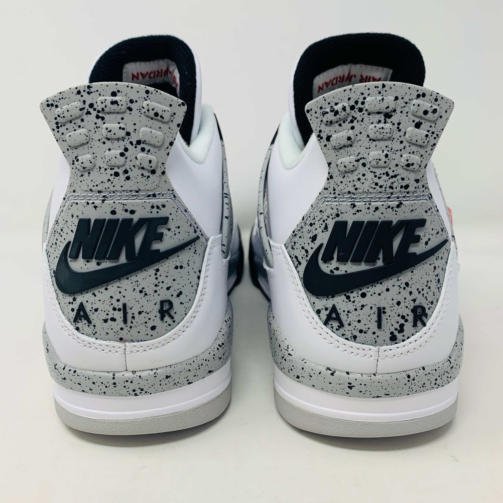 Check out the Jordan 4 White Cement 2016, a white sneaker with black and gray speckles. It features a small red jumping logo, comes in a matching box, and includes the classic 2016 Jordan hang tag for authenticity.