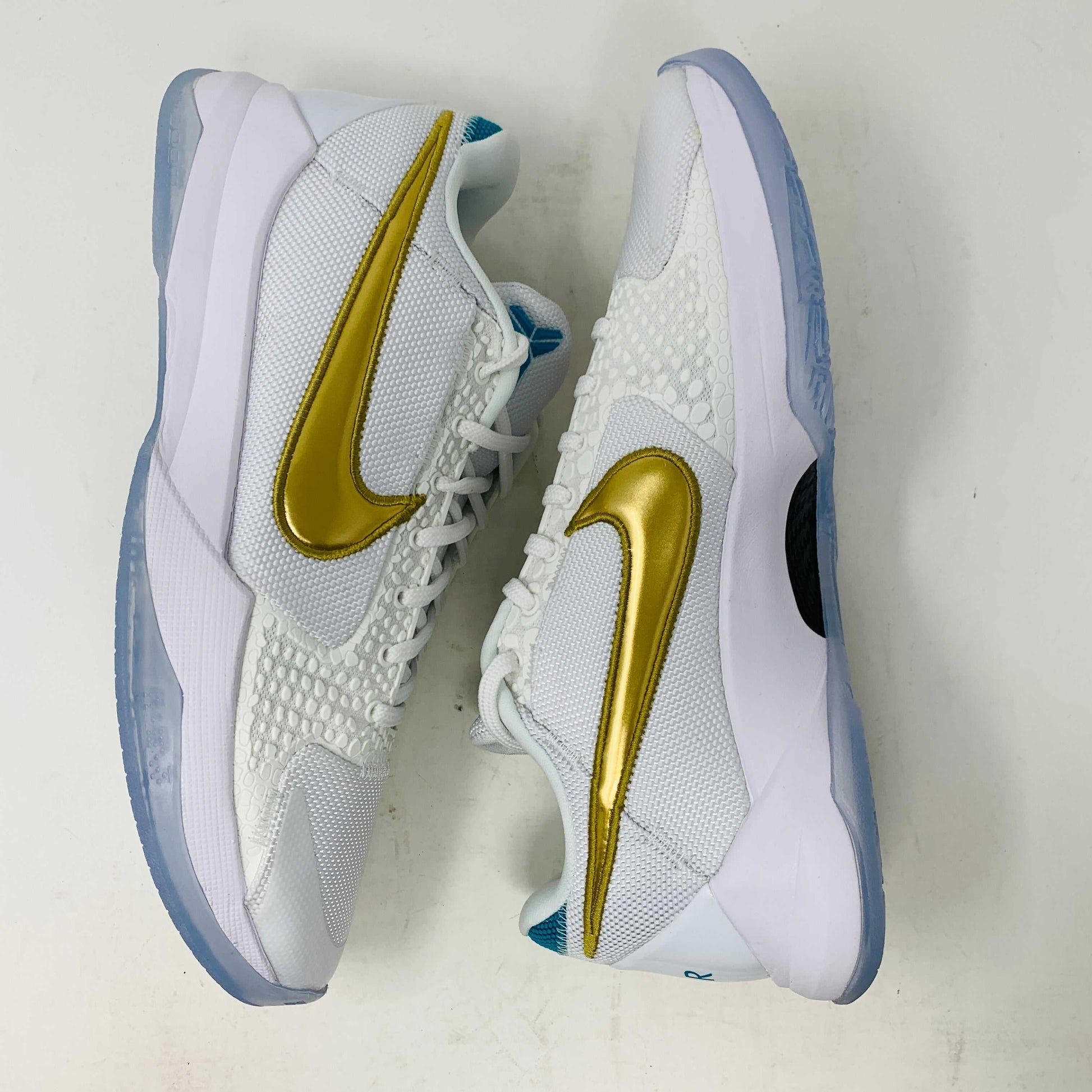 Kobe V Protro Undefeated Pack sneakers with gold accents and premium materials.