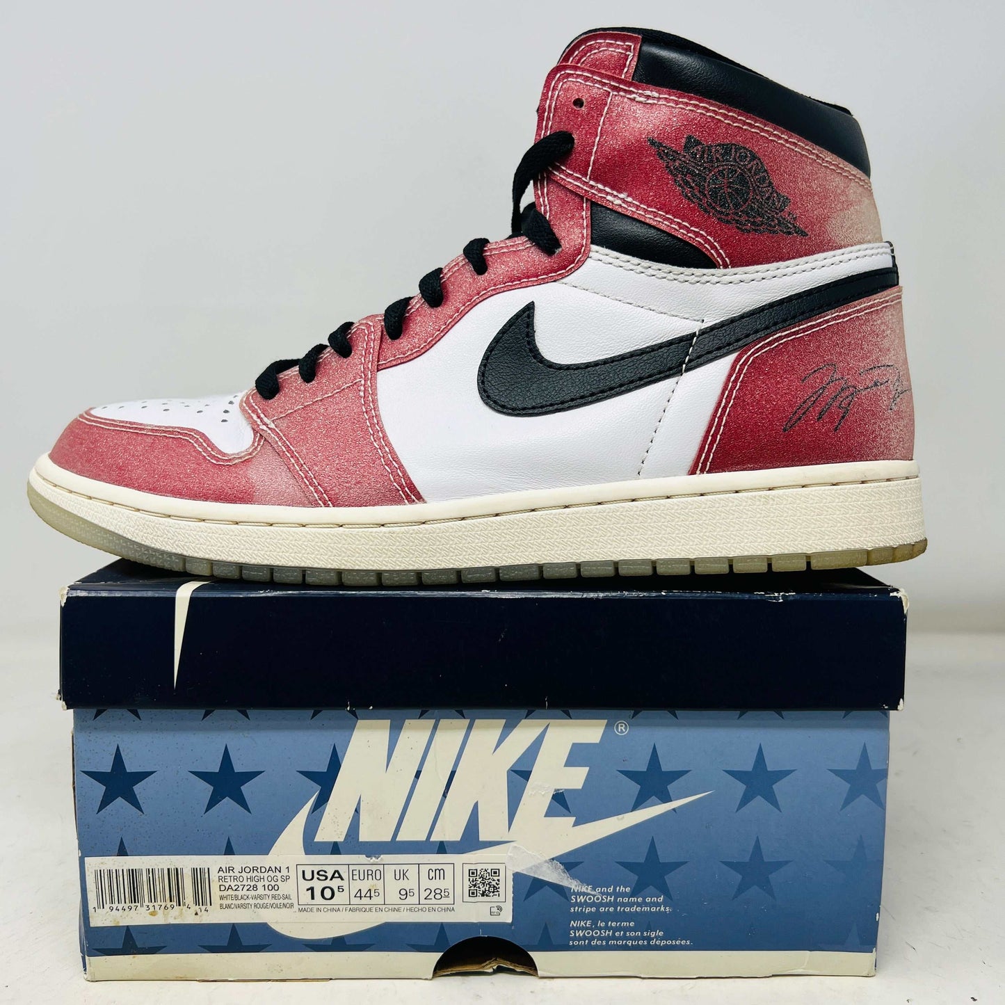 Jordan 1 Retro High Trophy Room Chicago sneaker on Nike box, white and red with black accents, lightly worn 2021 edition