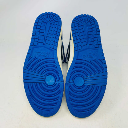 The Jordan 1 Retro High OG SP Fragment x Travis Scott is a new high-top sneaker featuring a blue, white, and black design with a unique backward Nike swoosh. It comes in a transparent, branded box adorned with butterfly and text details, boasting a thick sole and classic 1985 Air Jordan design.