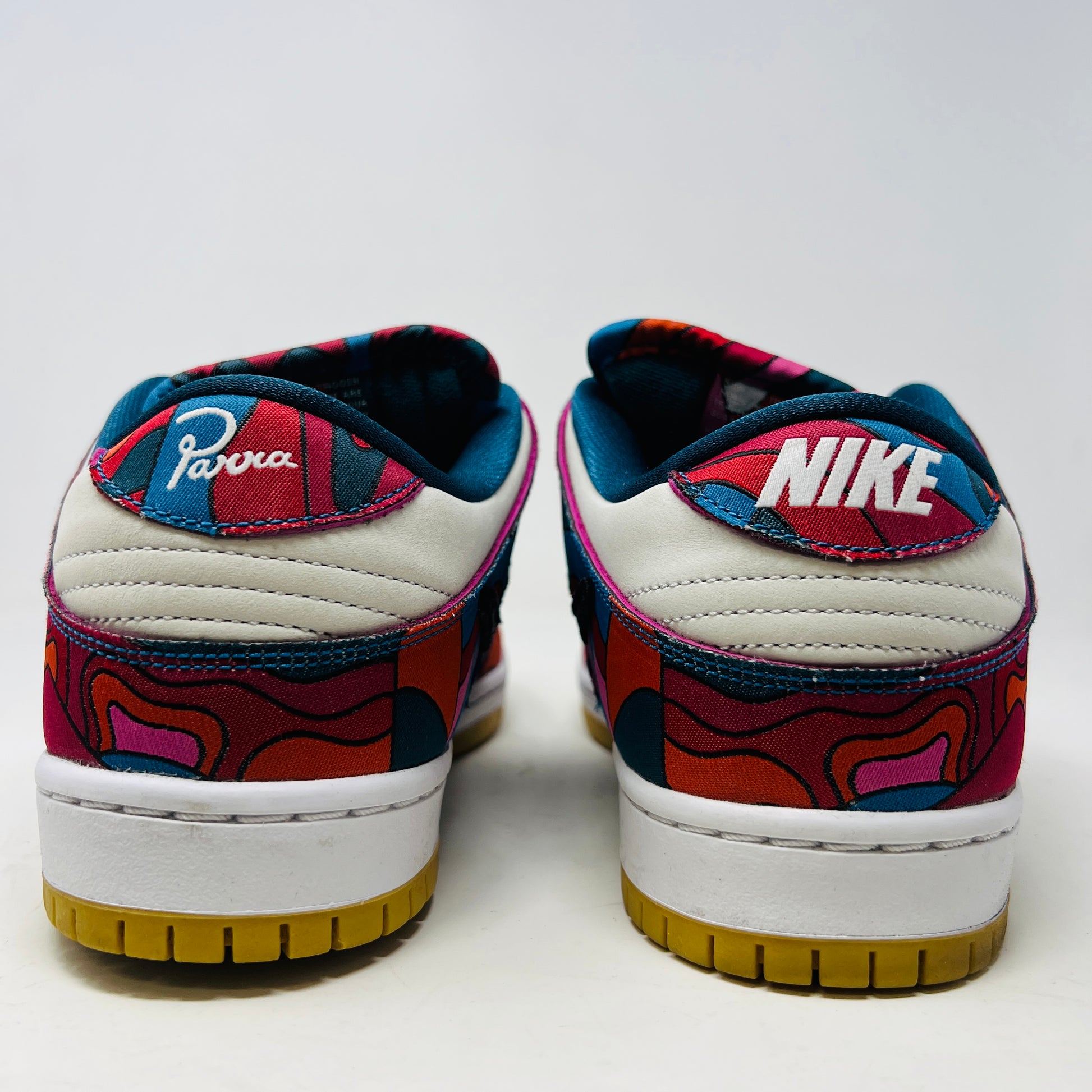 The Nike SB Dunk Low Pro Parra Abstract Art (2021) features a colorful design with abstract red, blue, and purple patterns on a white base. It includes clean uppers with a black swoosh, white laces, and comes in a green/yellow box with extra blue laces for added versatility.
