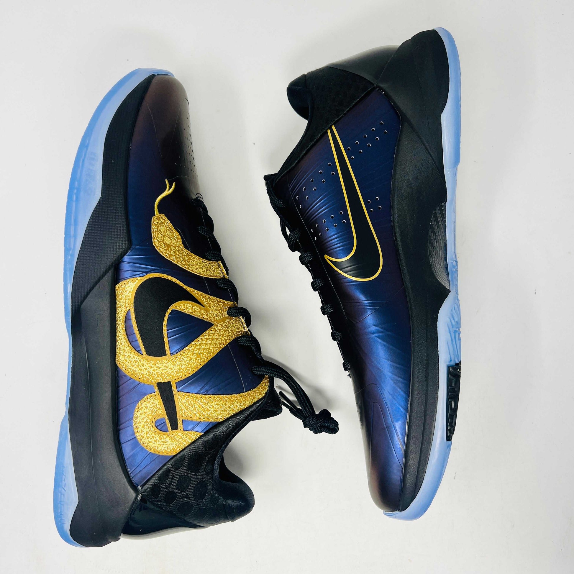The Nike Kobe 5 Protro Year of the Mamba Eggplant sneakers offer a stylish design with purple and gold colors, black laces, and an authentic tongue logo. They feature perforated side panels, a shiny finish, and include a dust bag for easy storage.