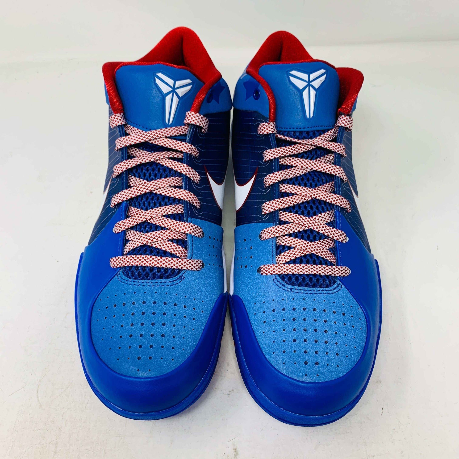 The Nike Kobe 4 Protro Philly (2024) basketball shoes are blue with red interiors and laces, featuring a white Nike logo on the tongue. They include perforated detailing on the toe area and a white swoosh on the sides, all set against a white background.
