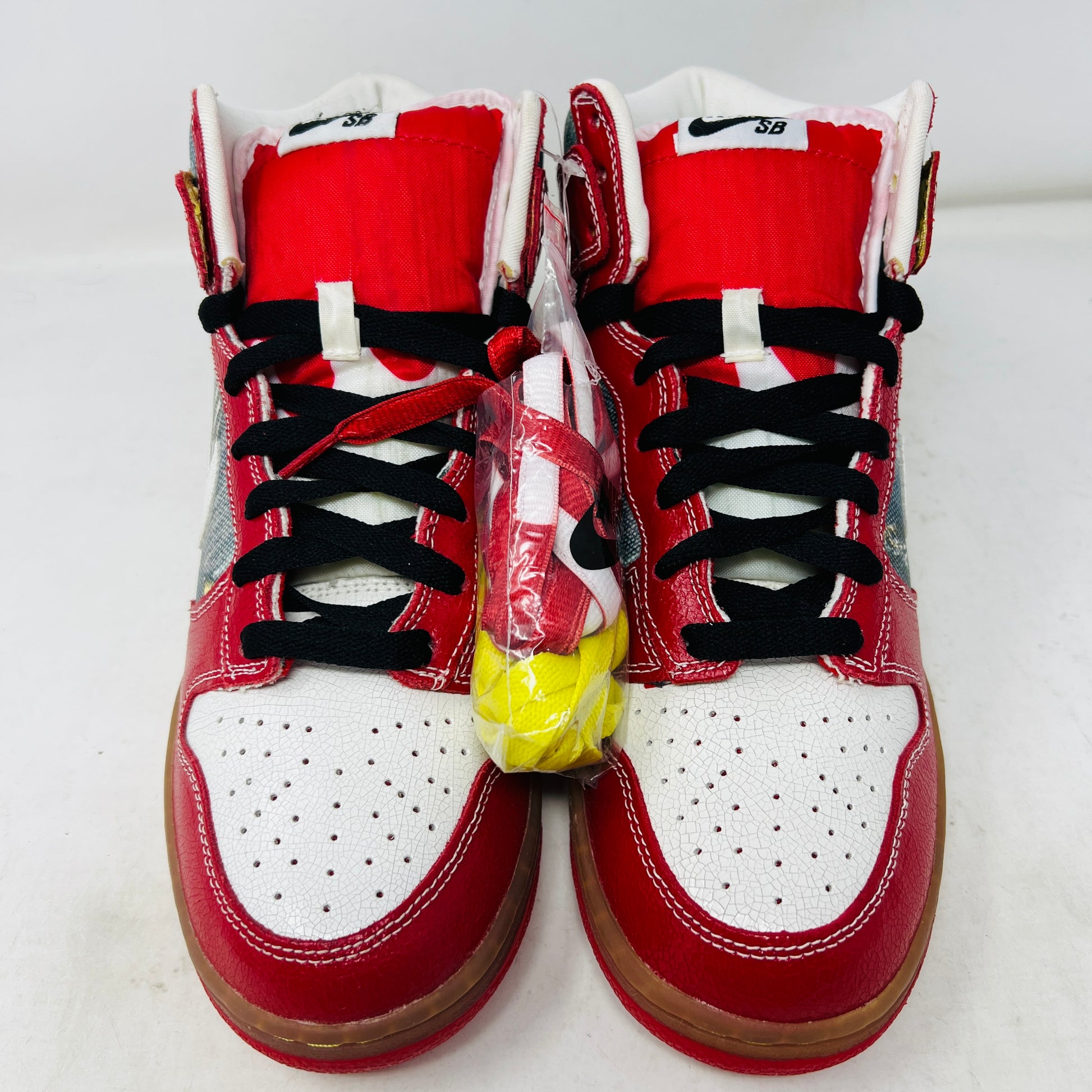 The Nike SB Dunk High Shoe Goo from 2008, priced at $525, sits atop its box. It features red and blue denim sections, a white swoosh, and a gum sole. A tag shows size and numbers, with extra laces beside the shoebox.