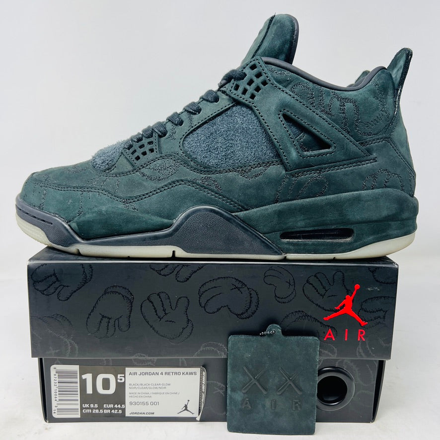 A dark green suede sneaker with a textured design, reminiscent of OG ALL styles, sits atop a matching box. Tagged size 10.5, it features a small red Jumpman logo and includes a XX AIR keychain from its 2017 release. Product: Jordan 4 Retro Kaws Black by Jordan.