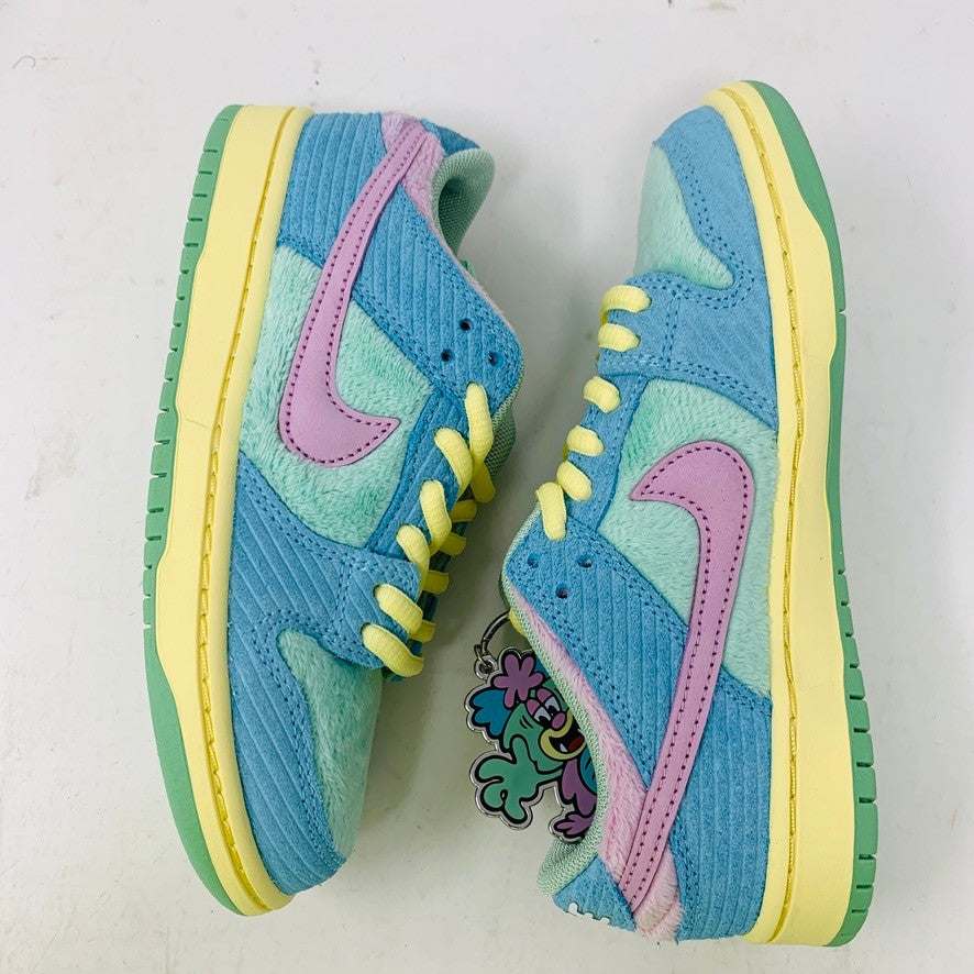 The 100% authentic Nike SB Dunk Low Verdy Visty (PS) sneaker showcases blue, pastel yellow, pink, and mint green accents with textured fabric and a pink swoosh. It is displayed atop a white Nike SB shoebox.