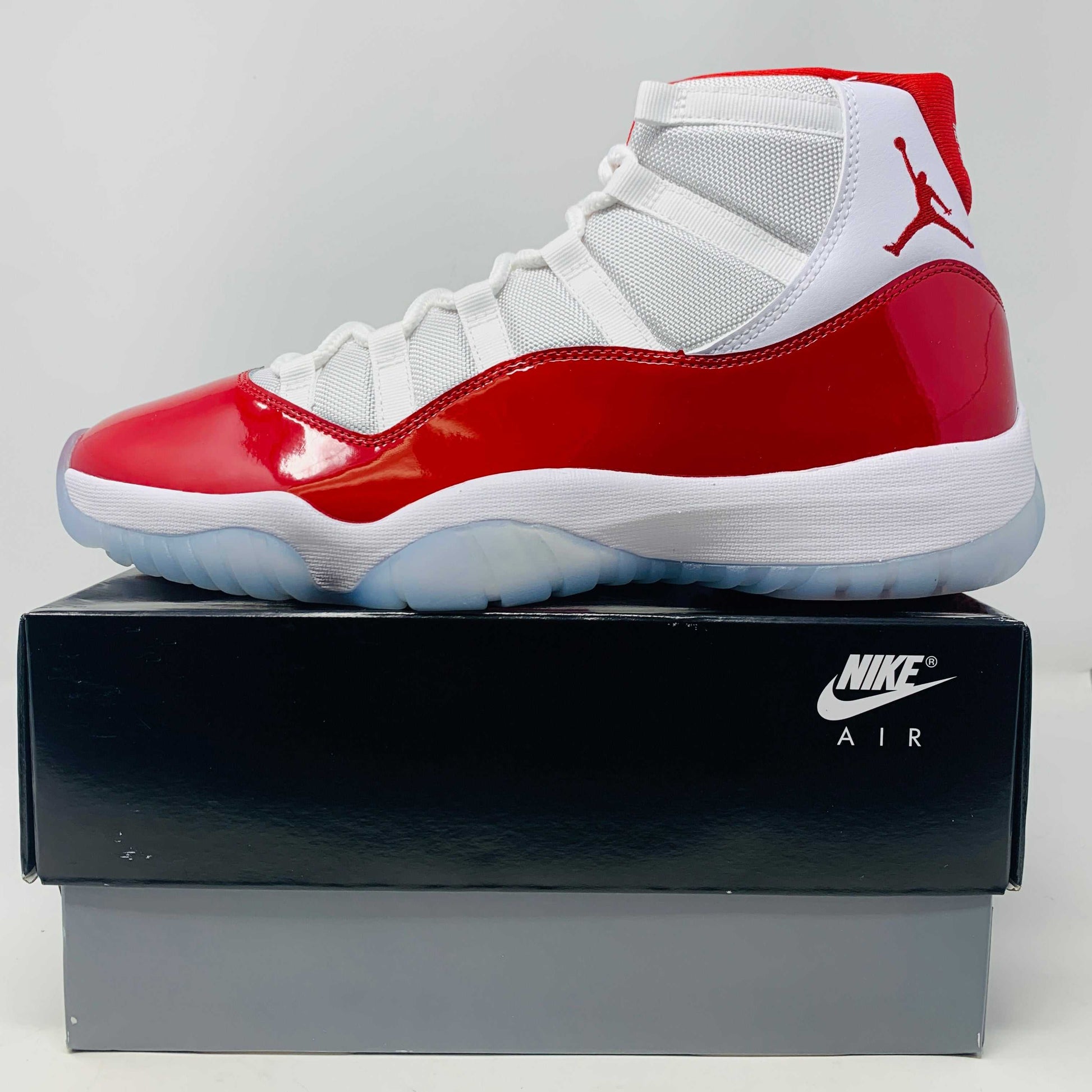 Jordan 11 Retro Cherry 2022 sneaker, brand new, red and white design, displayed on Nike Air box.