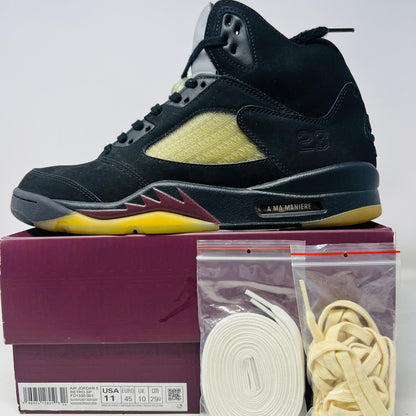 The Jordan 5 Retro A Ma Maniére Dusk sneakers feature clean black and maroon uppers, a vibrant yellow sole, and the number 23. They come with extra white and cream laces in plastic bags on a maroon shoebox displaying various sizes. Ideal for any light wear occasion.