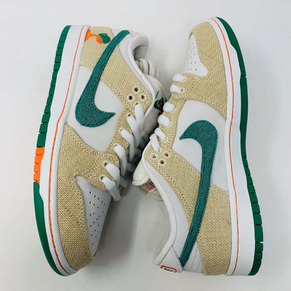 Front view of a brand new pair of Nike SB Dunk Low Jarritos sneakers in beige and white with green accents, featuring textured beige material, perforated toe panels, white laces, and swoosh logos on the tongues. Extra 2 laces included; displayed on a plain white background.