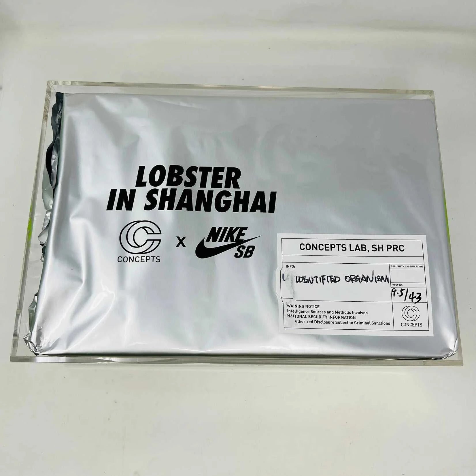 The Nike SB Dunk Low Concepts Green Lobster sneakers, with silver Swooshes and displayed on their Shanghai Special Box, come with extra pink and black laces. They feature green midsoles and a checkered inner lining for that iconic touch.