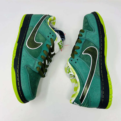 The Nike SB Dunk Low Concepts Green Lobster sneakers, with silver Swooshes and displayed on their Shanghai Special Box, come with extra pink and black laces. They feature green midsoles and a checkered inner lining for that iconic touch.