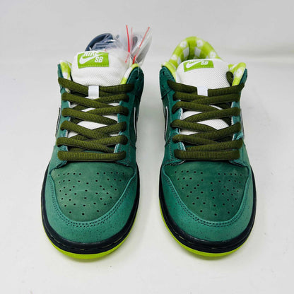 The Nike SB Dunk Low Concepts Green Lobster sneakers, with silver Swooshes and displayed on their Shanghai Special Box, come with extra pink and black laces. They feature green midsoles and a checkered inner lining for that iconic touch.