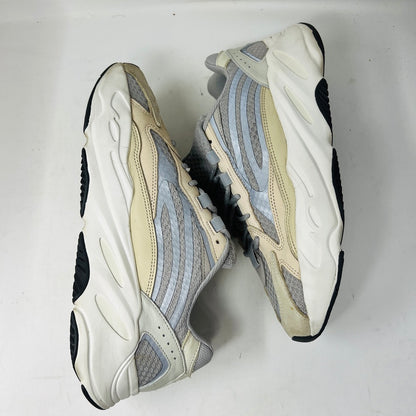 Adidas Yeezy Boost 700 V2 Cream sneakers in beige, gray, and white rest on a brown box labeled Yeezy Boost 700, Made by Adidas, showing minor wear. Box size label: 11.5.