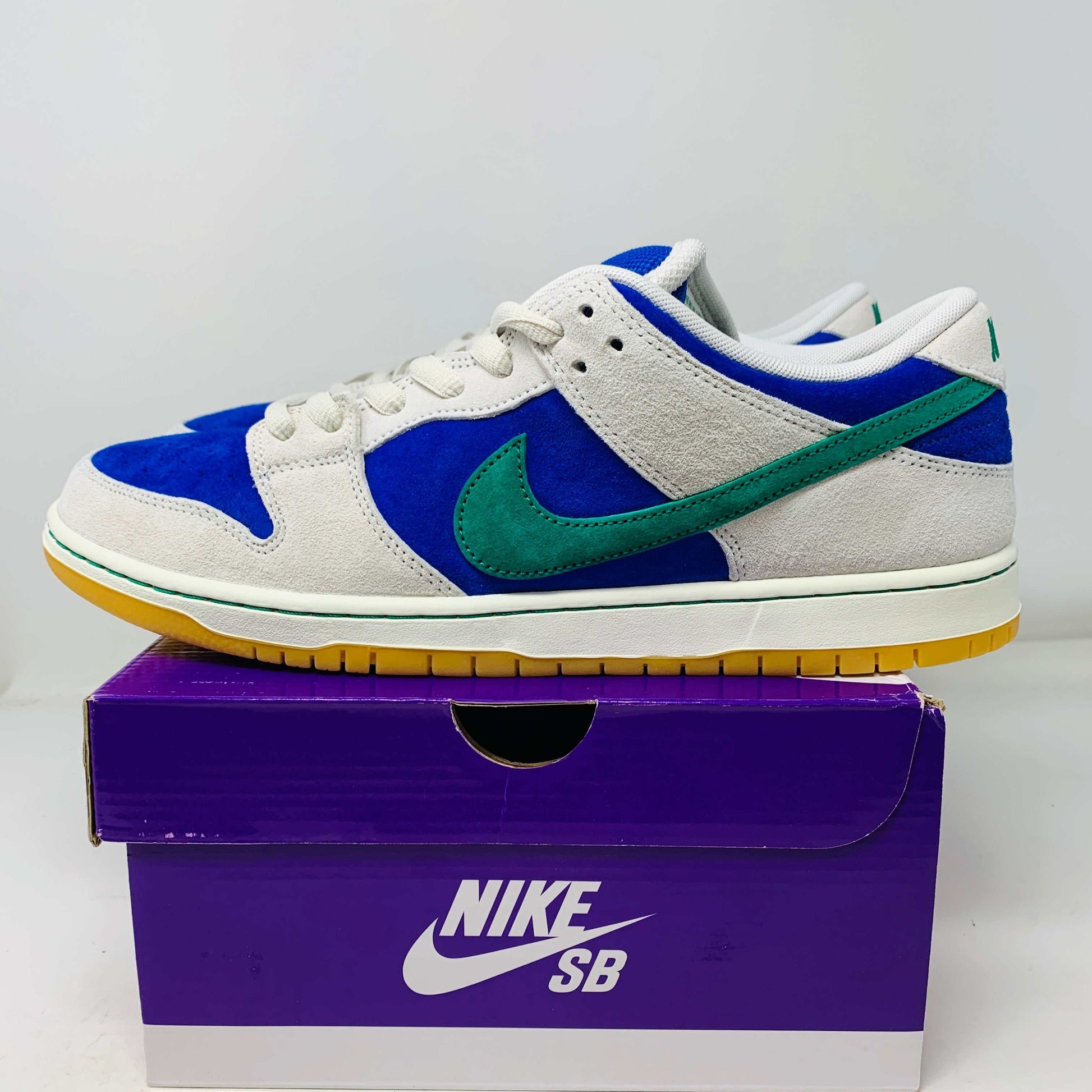 Nike SB Dunk Low Hyper Royal Malachite sneakers in new condition with extra laces, displayed on a purple box.