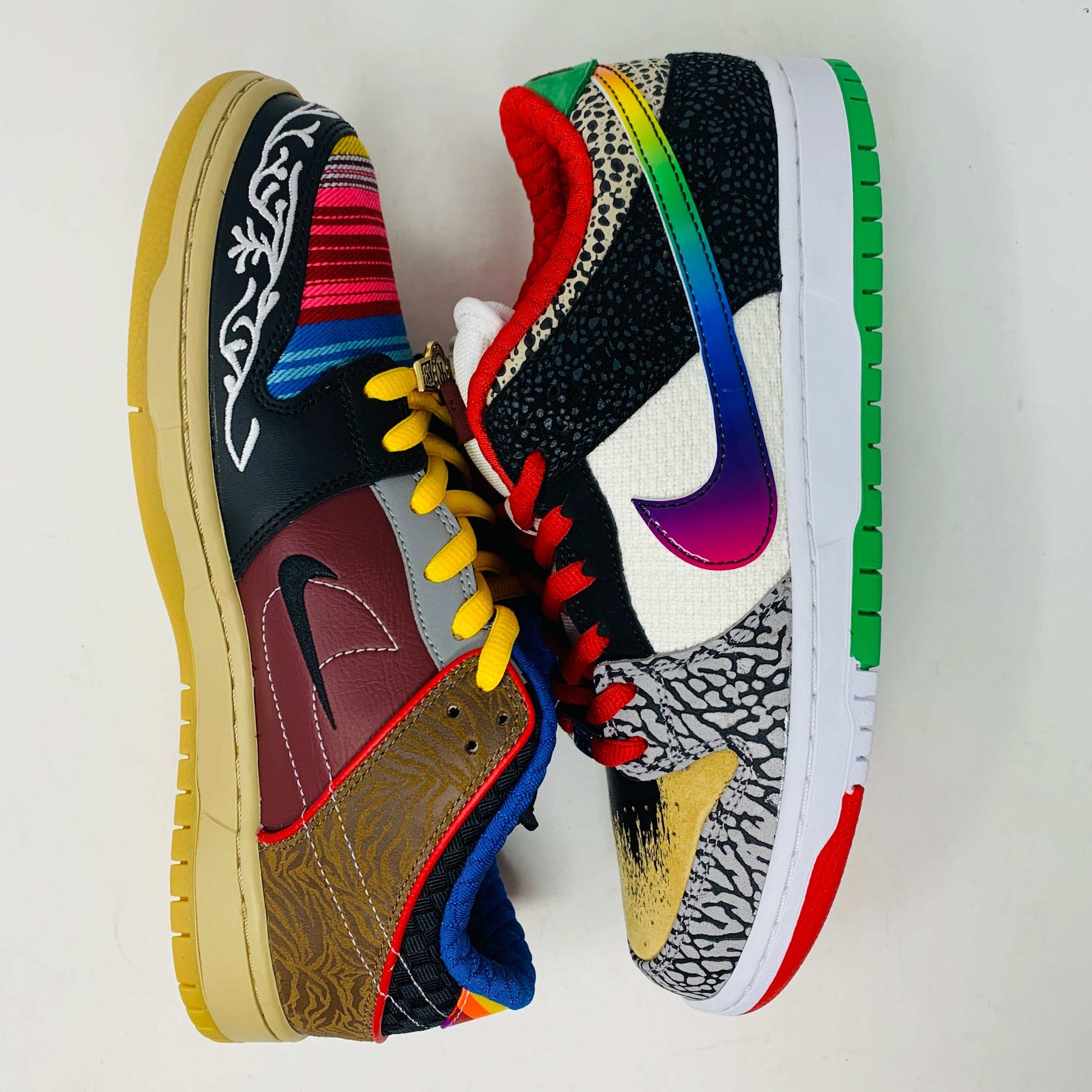 The Nike SB Dunk Low What the Paul is a 2021 authentic sneaker featuring varied textures and patterns like elephant print, a gradient swoosh, red laces, and comes in a colorful green, yellow, and white Nike SB box.