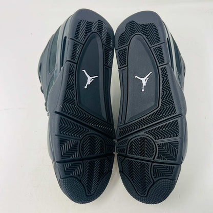 Jordan 4 RM Black Cat sneakers with sleek black design and grey accents, showcasing the outsole and premium leather.