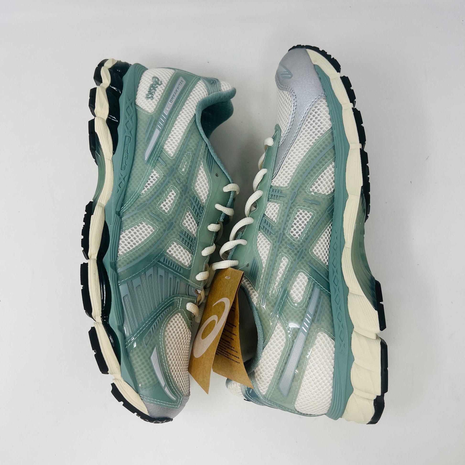 The ASICS Gel-Kayano 12.1 Kith Cream Sage sneakers in pastel green and white feature a breathable mesh design. Theyre accompanied by two packs of extra laces (green and white with black speckles), offering versatile styling for your 100% authentic needs.