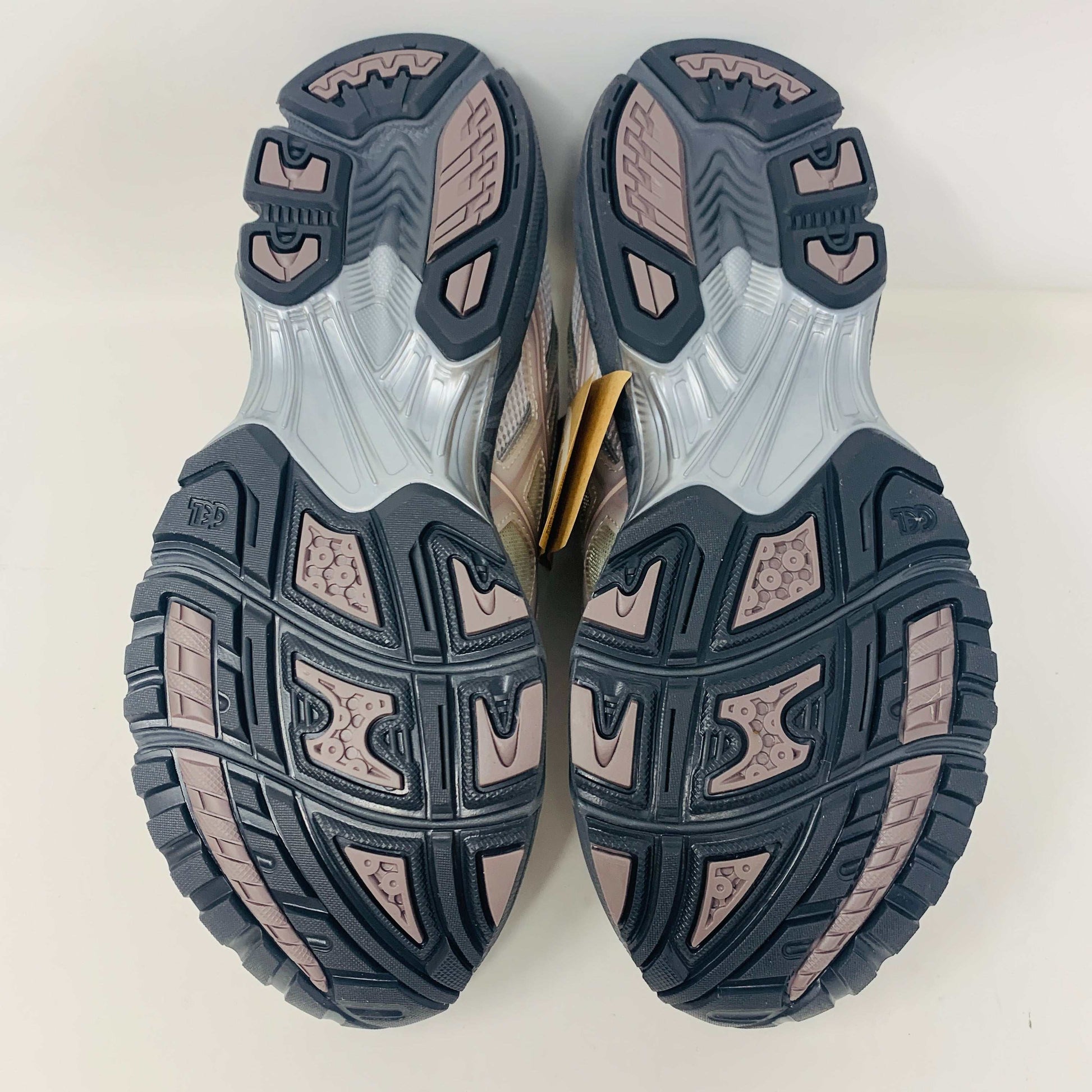 The ASICS Gel-Nimbus 10.1 Kith White Morganite features white, gray, and light pink tones displayed on a shoebox. Includes two sets of laces: one brand new in white with black specks and one plain beige, sealed in plastic bags, ready for 2024.
