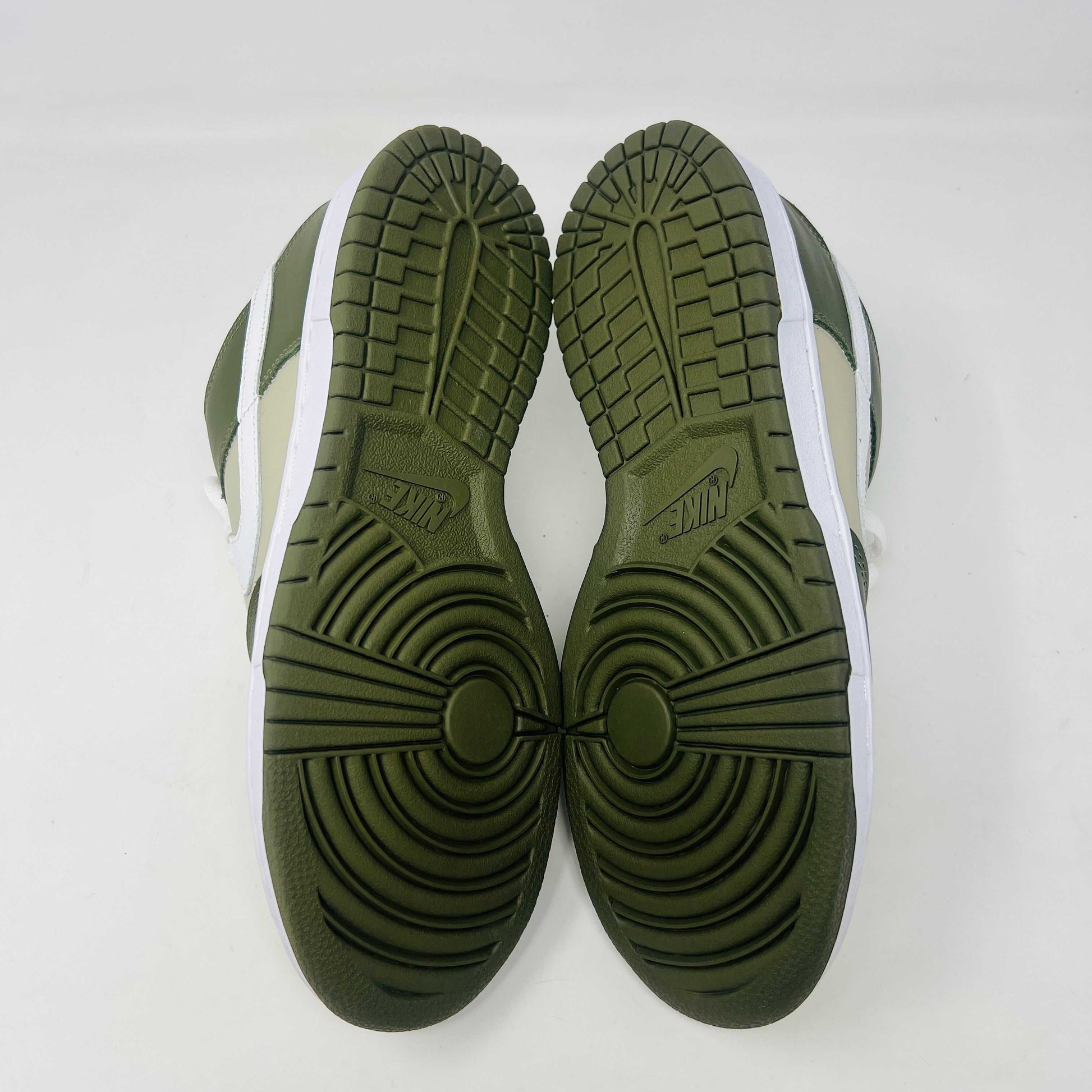 A Nike Dunk Low Light Stone shoe in green and beige with brand new white laces is displayed atop an orange Nike box. Extra white laces are in front, ensuring this 100% authentic pair from the Nike Dunk collection is ready to step out in style.
