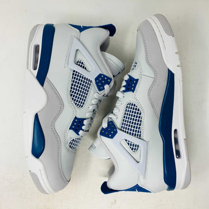 The Jordan 4 Retro Military Blue (2024) sneaker, with white and blue mesh details and a visible air cushion, rests on a black speckled NIKE AIR box with bold orange text. It is 100% authentic, including orange tags, ensuring it’s brand new.