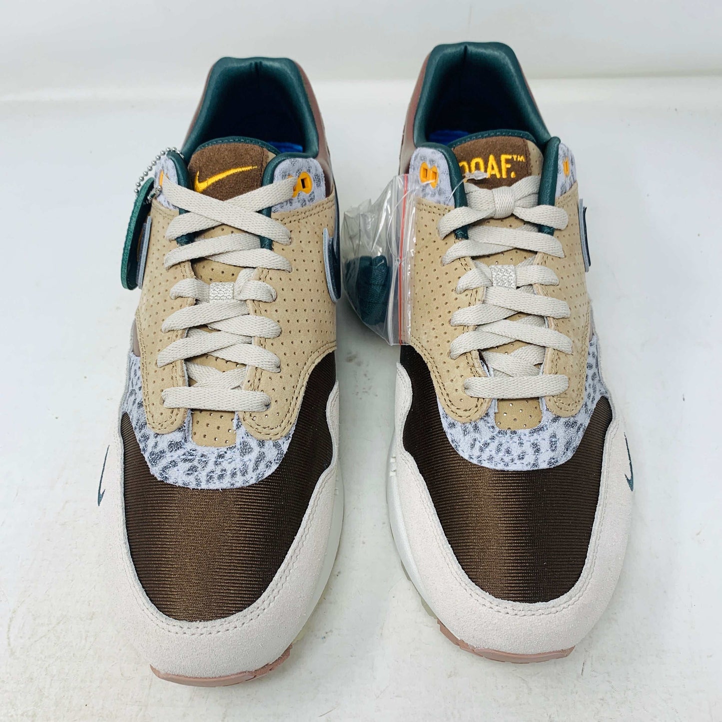 The Nike Air Max 1 87 Premium University of Oregon PE (2024) is a stylish, brand new sneaker featuring a blend of beige, purple, and leopard print with perforated and smooth leather textures. It comes in a vibrant green box and includes a visible air unit in the sole.