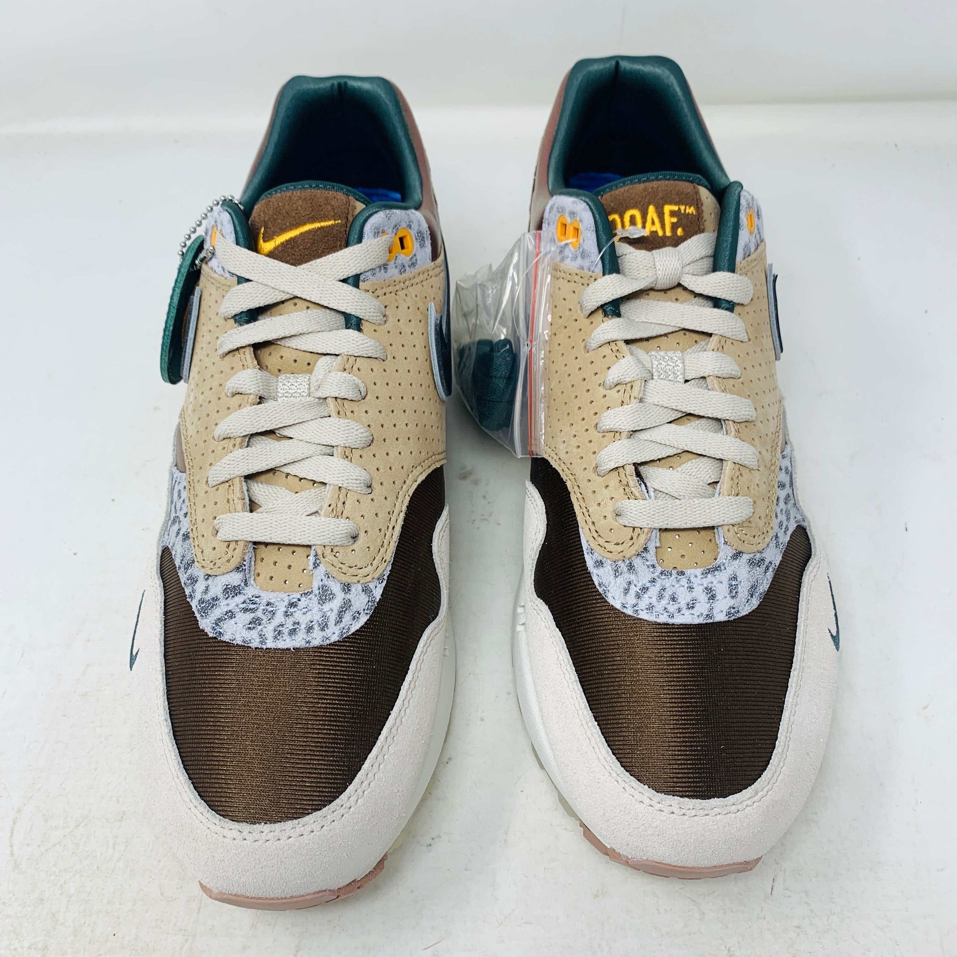 The Nike Air Max 1 87 Premium University of Oregon PE (2024) is a stylish, brand new sneaker featuring a blend of beige, purple, and leopard print with perforated and smooth leather textures. It comes in a vibrant green box and includes a visible air unit in the sole.