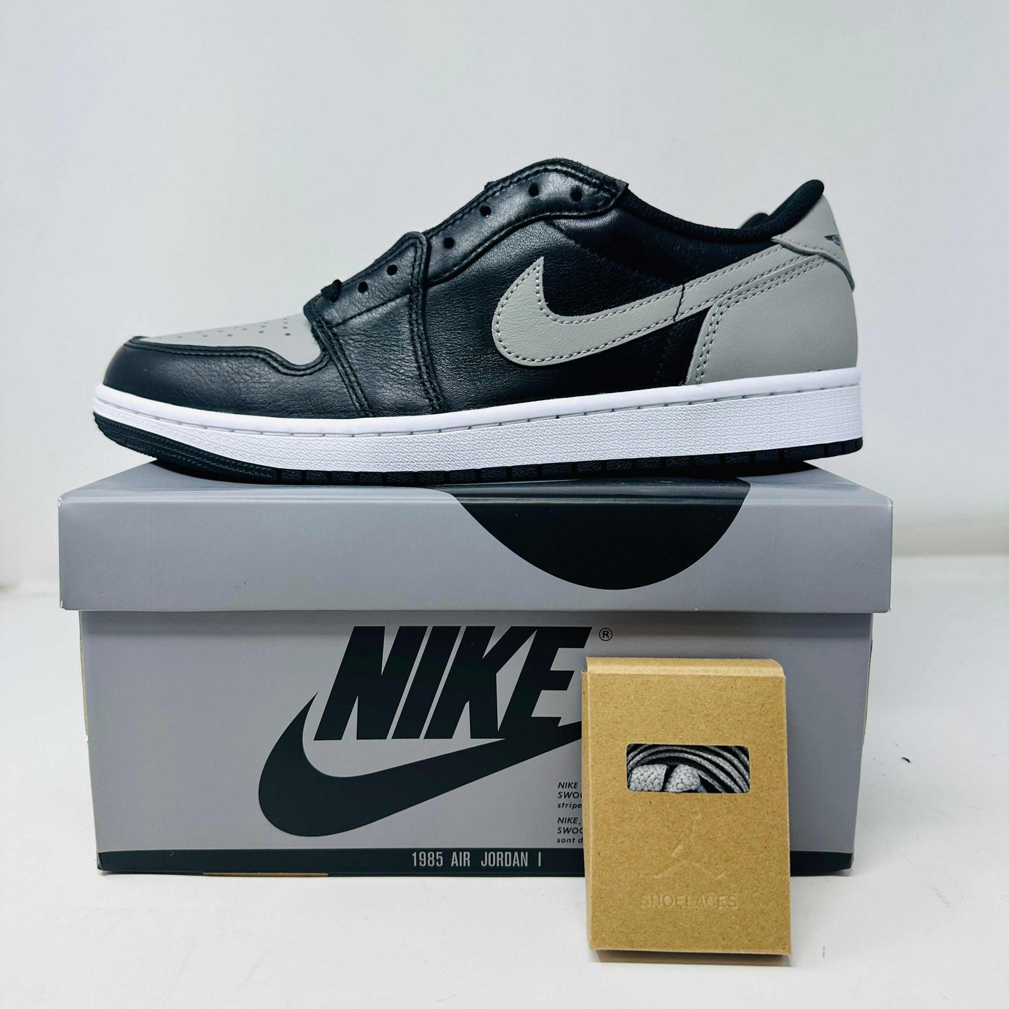 Jordan 1 Low OG Shadow 2024 sneakers with extra laces on Nike box.