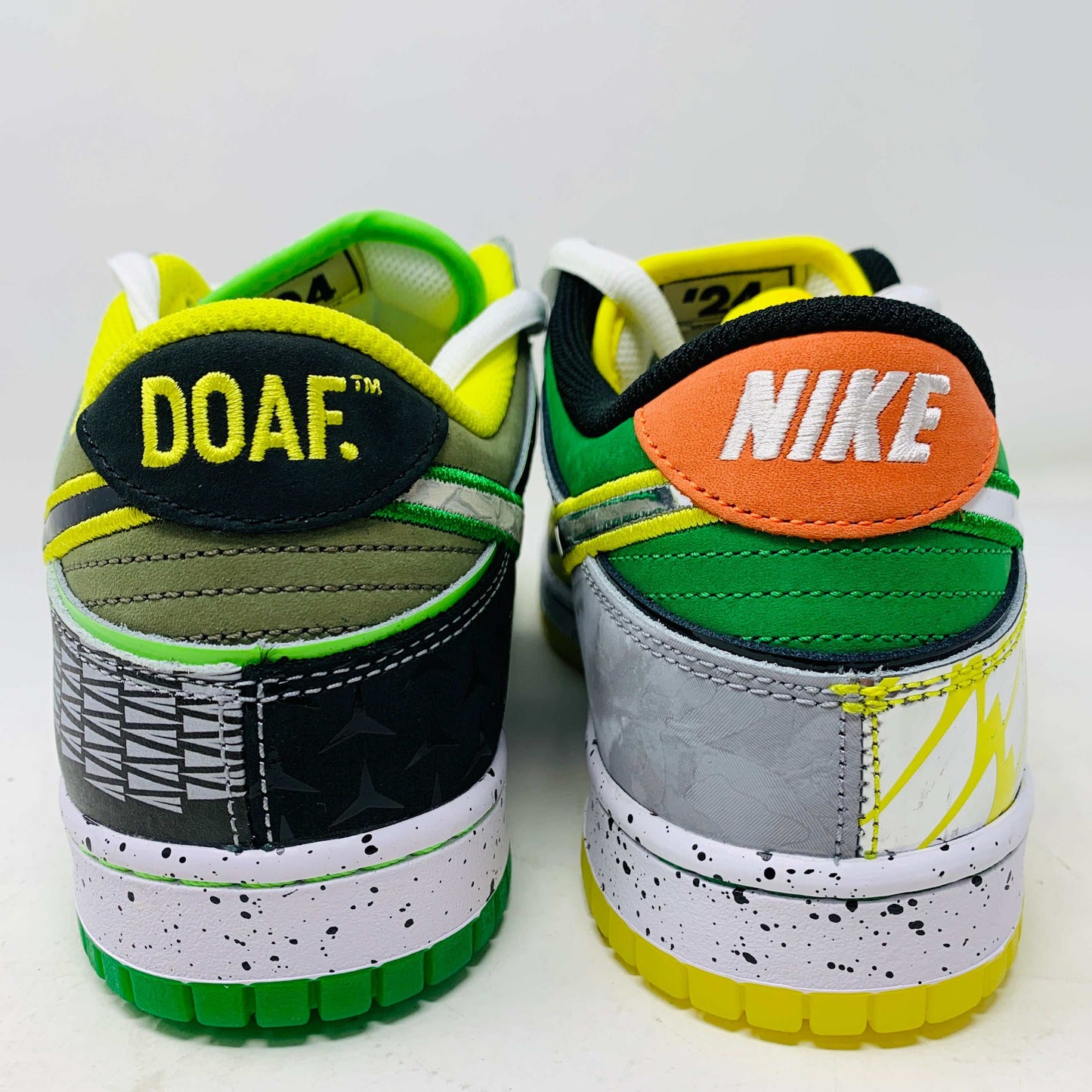 The Nike Dunk Low What the Duck Away University of Oregon PE is a vibrant sneaker featuring green, white, and black patterns with a black Nike swoosh outlined in yellow. It includes white laces, extra laces, a speckled white midsole, and a padded yellow lining atop a bright green shoebox. 100% authentic.
