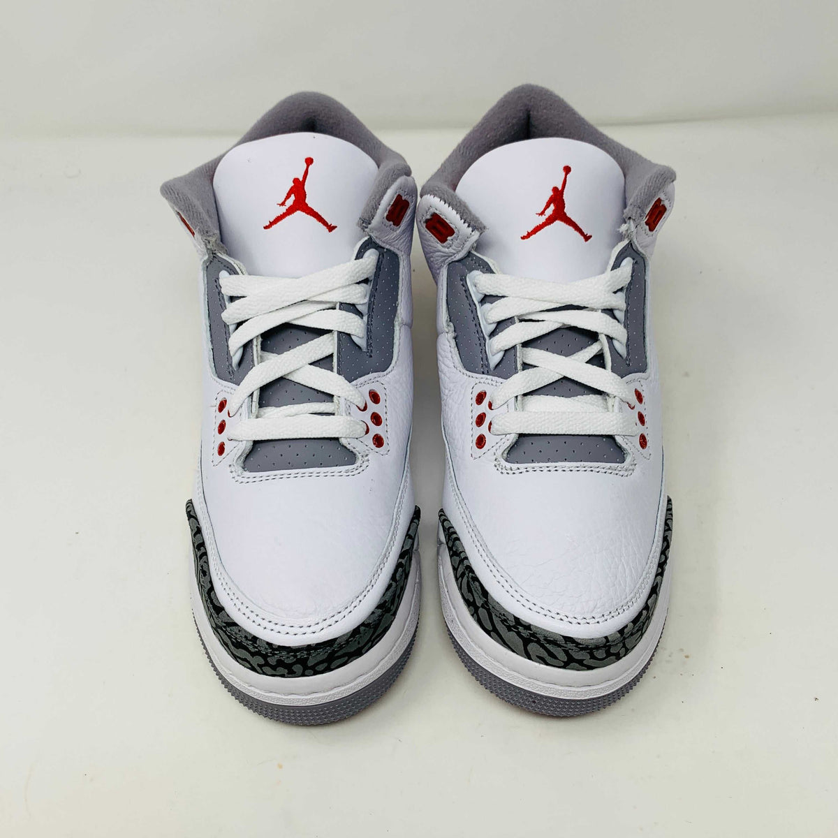 The Jordan 3 Retro Fire Red (2022) (GS) features white, red, and gray colors with elephant-print accents on a black-and-gray patterned box. The box has a red jumping silhouette and bold AIR lettering, making this BRAND NEW release ideal for collectors and enthusiasts.