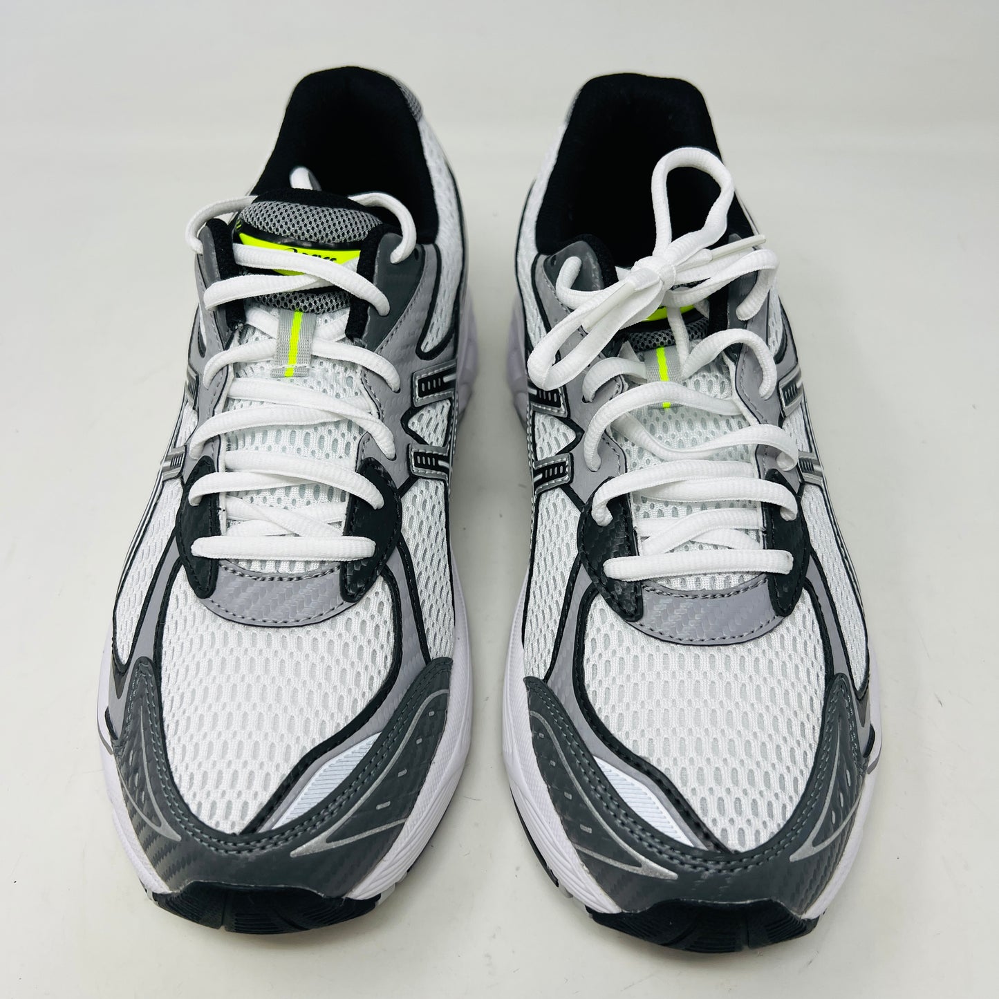 A brand new pair of ASICS GT-2160 JJJJound White sneakers, featuring mesh details and black stripes, is displayed on a black ASICS shoe box with extra laces in front for a complete authentic look.