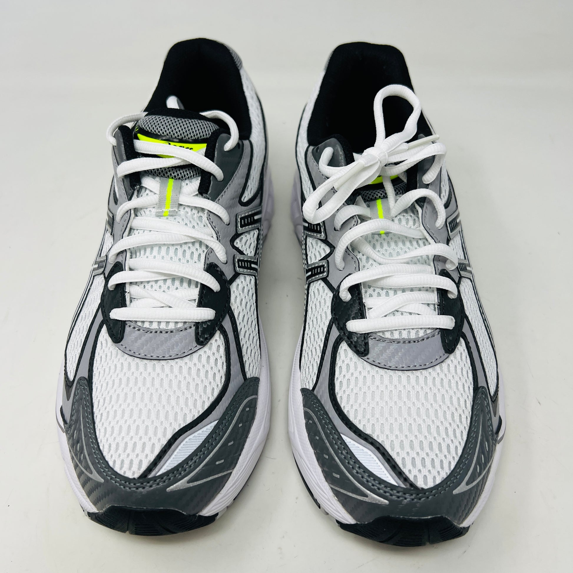 A brand new pair of ASICS GT-2160 JJJJound White sneakers, featuring mesh details and black stripes, is displayed on a black ASICS shoe box with extra laces in front for a complete authentic look.