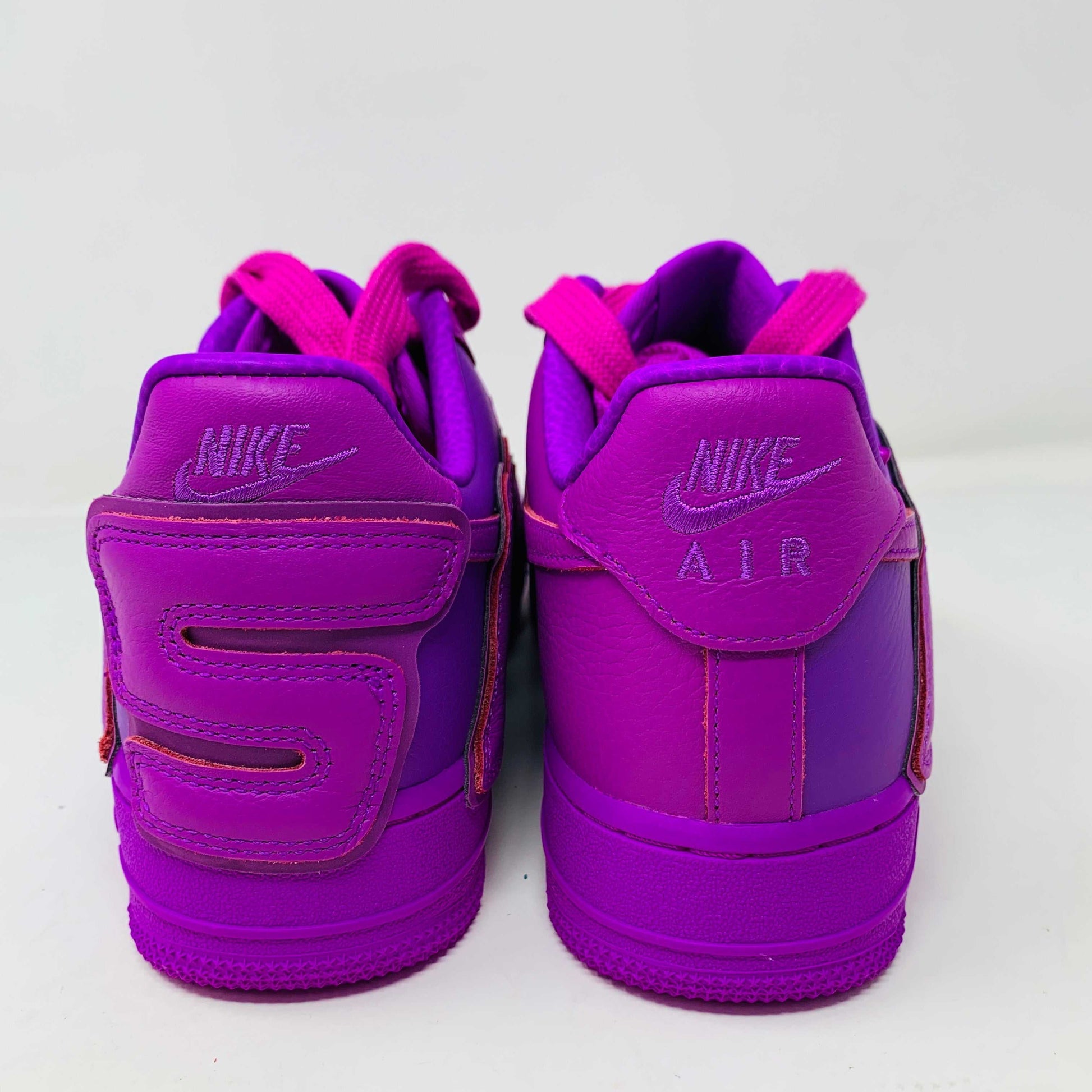 The Nike Air Force 1 Low Cactus Plant Flea Market Fuchsia Dream sneaker, vibrant pink with oversized SUN lettering, boldly sits on a black box featuring the iconic white swoosh. This brand new, 100% authentic pair includes extra laces and is presented against a plain white background.