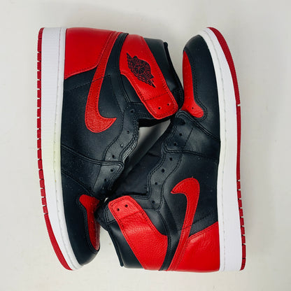 The Jordan 1 High Bred 2016 sneakers, by Jordan, are brand-new black and red high-tops with a white sole. Viewed from above, they showcase an unlaced look with a perforated design on the toe area.