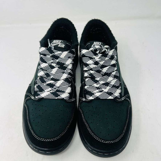 A pair of Jordan 1 Retro Low OG SP Travis Scott Black Phantom sneakers with perforated toe boxes and black and white checkered laces includes extra laces for added style. These authentic Jordans are displayed side by side on a white surface.