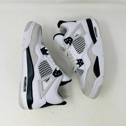 The Jordan 4 Military Black GS sneakers, featuring distinctive side netting and a logo on the tongue, are brand new and authentic in white and gray with black accents. They face forward on a white surface against a plain background, embodying modern style.
