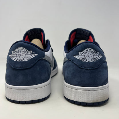 A Jordan 1 Low SB Midnight Navy shoe from Jordan, featuring blue toe and heel, white side panels, and a silver swoosh, is displayed on its box. The VERY CLEAN UPPERS are complemented by the size and product info visible on the label.