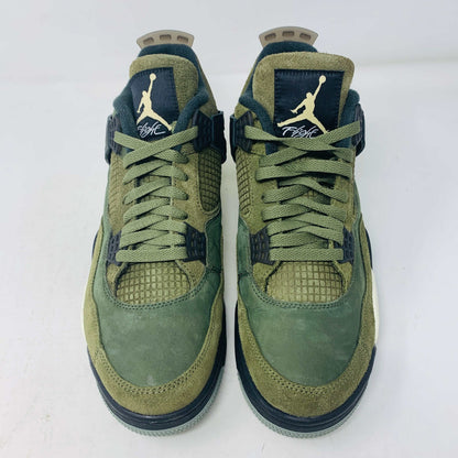 The Jordan 4 Retro SE Craft Medium Olive sneakers feature a blend of green, black, and white with a mesh and suede texture. Elegantly presented on a green shoebox against a white backdrop, they epitomize 100% authentic craftsmanship by Jordan.
