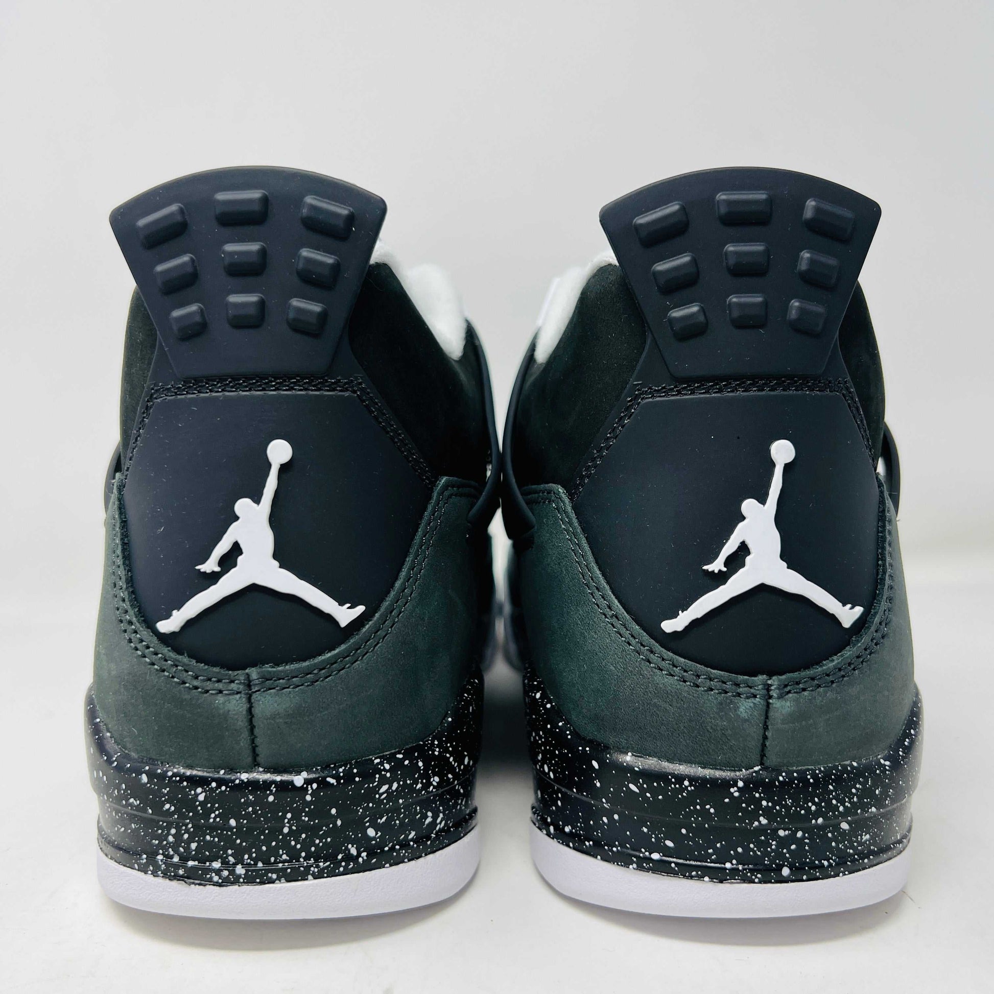 On top of a shoebox sits the brand-new Jordan 4 Retro Fear (2024), a stylish sneaker by Jordan. Its black and gray color scheme, black mesh accents, white midsole, and speckled heel details make it a must-have for 2024.