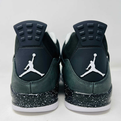 On top of a shoebox sits the brand-new Jordan 4 Retro Fear (2024), a stylish sneaker by Jordan. Its black and gray color scheme, black mesh accents, white midsole, and speckled heel details make it a must-have for 2024.