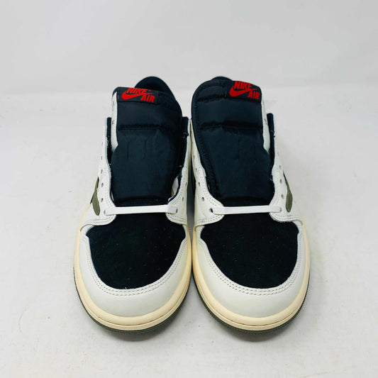 A black, white, and olive green Jordan 1 Retro Low OG SP Travis Scott Olive (W) sneaker from Nike is displayed on a matching box. This brand new shoe sports a large reversed swoosh and cream-colored sole. The box showcases the green Nike logo with 1985 Air Jordan 1 text for these authentic 2023 shoes.