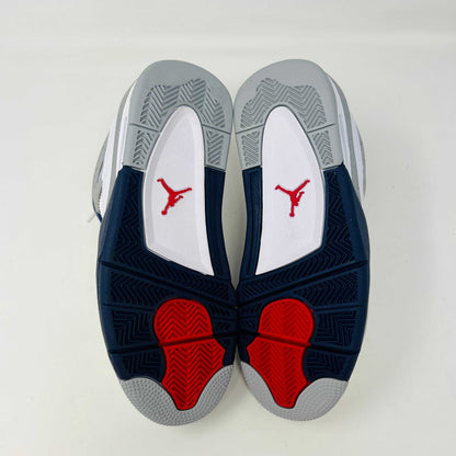 A brand new Jordan 4 Retro Midnight Navy (GS) sneaker from 2022 sits atop a red Nike shoe box with the iconic swoosh, featuring a white and gray design, leather and mesh mix, dark blue accents, and a visible air unit in the sole.