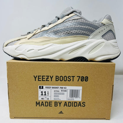 Adidas Yeezy Boost 700 V2 Cream sneakers in beige, gray, and white rest on a brown box labeled Yeezy Boost 700, Made by Adidas, showing minor wear. Box size label: 11.5.